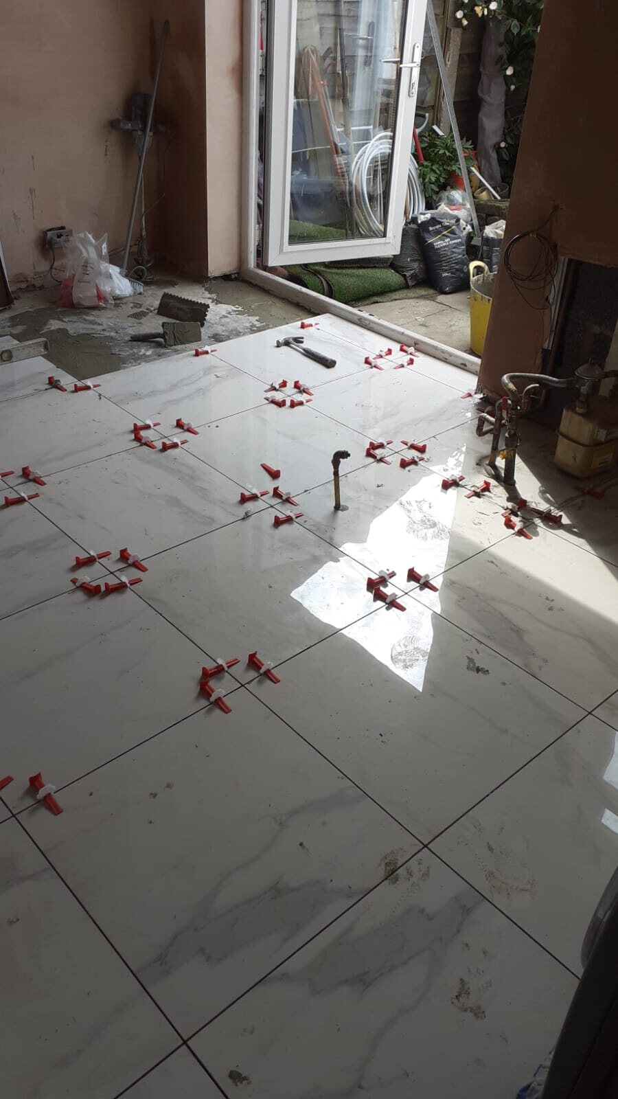 Large format floor tiles being laid in the kitchen